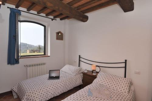 a bedroom with two beds and a window at Casale Vecchio Fienile in SantʼAppiano