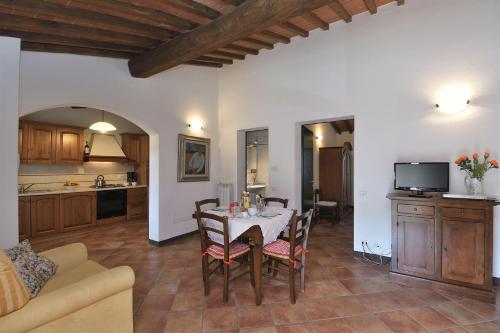 a kitchen and living room with a table and chairs at Casale Vecchio Fienile in SantʼAppiano