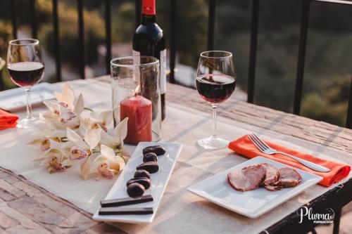 a table with two glasses of wine and a plate of food at Hotel San Jorge in Tlatlauquitepec