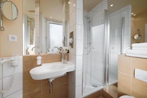 a bathroom with a sink and a shower at Hotel City House in Hamburg