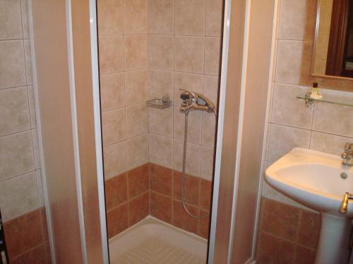 y baño con ducha y lavamanos. en Guesthouse Rodavgi, en Kato Loutraki