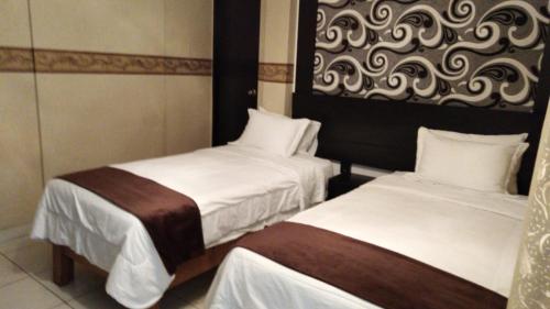 a hotel room with two beds with white sheets at Monterrico Hotel Perú in Lima