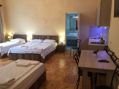 a hotel room with two beds and a table at Hotel Good Luck in Kutaisi
