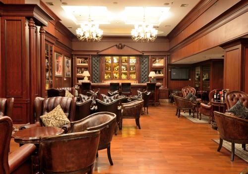 um restaurante com cadeiras e mesas de couro numa sala em Guangzhou Victoria Hotel em Guangzhou