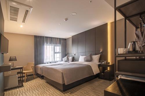 Hotel Foret Premier Nampo في بوسان: غرفه فندقيه سرير وتلفزيون