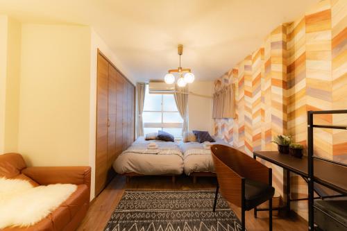 a small bedroom with a bed and a desk at Tasuki in Tokyo