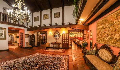 a living room filled with furniture and a chandelier at San Jose de Puembo Quito Airport, an Ascend Collection Hotel in Puembo