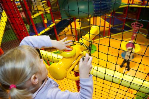 a little girl playing in a play structure at ibis Styles Saint Julien en Genevois Vitam in Neydens