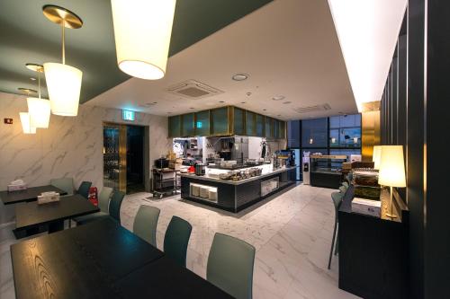 una cucina e una sala da pranzo con tavolo e sedie di Best Louis Hamilton Hotel Changwon a Changwon