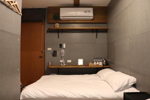 a bedroom with a white bed with aperature at Carefree Park in Taichung