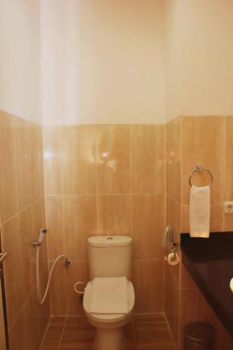 a bathroom with a toilet and a sink at Sutanraja Hotel & Convention Centre in Soreang