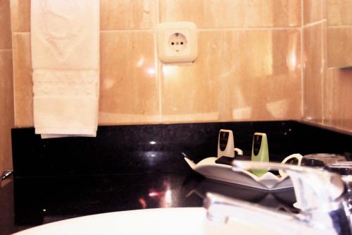 a bathroom with a sink and a mirror and a sink at Sutanraja Hotel & Convention Centre in Soreang