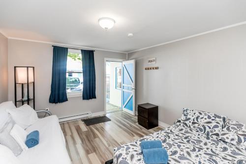 Schlafzimmer mit einem Bett und einem Fenster mit blauen Vorhängen in der Unterkunft Beachfront at Beach1 Motel in Wasaga Beach