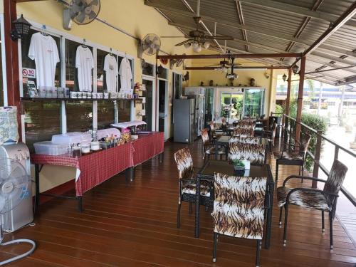 a restaurant with tables and chairs in a room at Baan Sabaijai Resort in That Phanom
