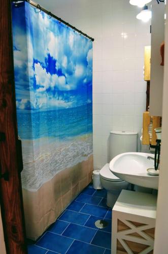 un bagno con tenda da doccia con WC e lavandino di La Barrosa duplex a Chiclana de la Frontera