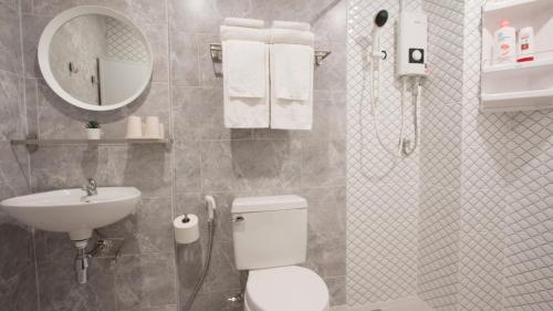 a bathroom with a toilet and a sink and a mirror at Neveu Premier Residence : Ratchada in Bangkok