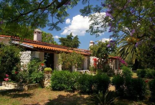 a house with a garden with flowers and plants at Marialice in Dassia