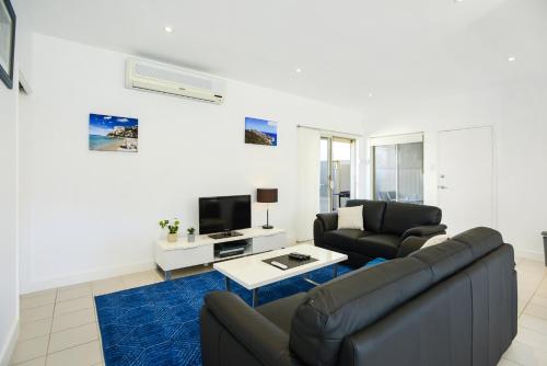 a living room with a couch and a tv at Blue Zone - Aldinga Beach - C21 SouthCoast Holidays in Aldinga Beach