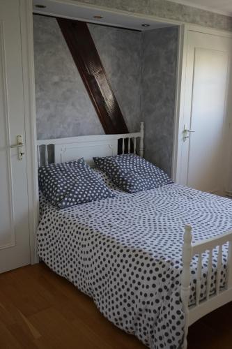- une chambre avec un lit blanc et une couette en noir et blanc dans l'établissement Les Roses de Rita, à Boisset-lès-Montrond