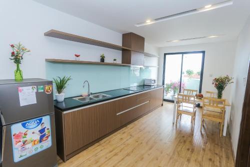 a kitchen with a sink and a refrigerator at HNC Premier Hotel & Residences in Hanoi