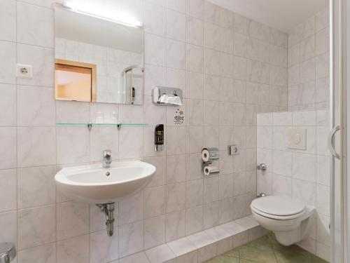a white bathroom with a sink and a toilet at Hotel Bohemia in Berlin