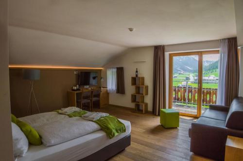 a bedroom with a bed and a couch and a window at Sport Hotel in Livigno