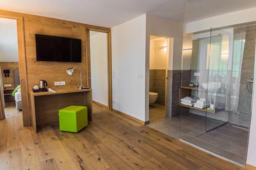 a bathroom with a shower and a television on the wall at Sport Hotel in Livigno
