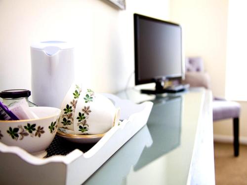 a white cabinet with bowls and a computer monitor on it at The Dartmouth Boutique B &B in Dartmouth