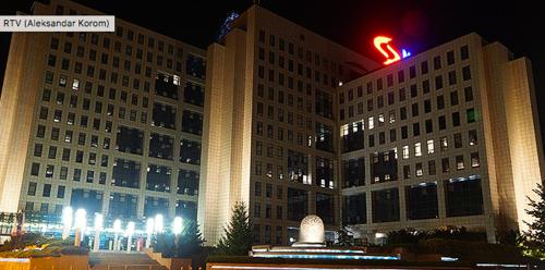a large building with a sign on it at night at Piccolo in Novi Sad