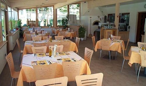 a restaurant with tables and white chairs and tables and tablesearcher at Laugen Cafè, Pizza, B&B in San Felice