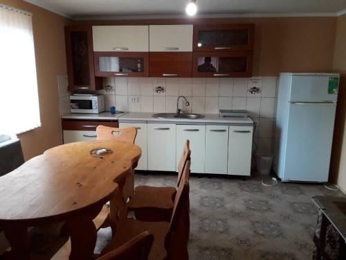 een keuken met een tafel, een wastafel en een koelkast bij Садиба "Ековид" in Krivorovnya