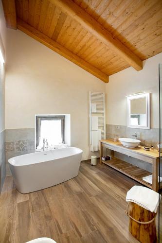 a large bathroom with a white tub and two sinks at Agr. Cascina Fabbrica in Fossano