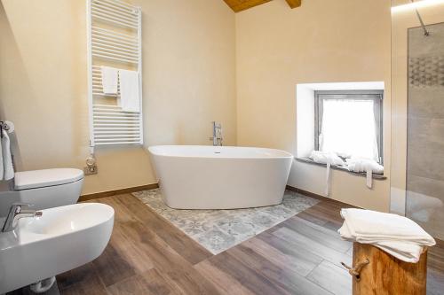 a bathroom with a tub and a toilet and a sink at Agr. Cascina Fabbrica in Fossano