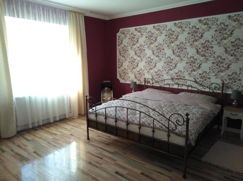 um quarto com uma cama com uma parede vermelha em Apartmán Nostalgie em Telč