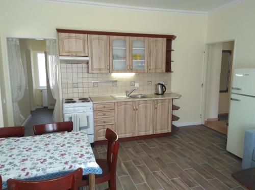 una cocina con armarios de madera, mesa y fregadero en Apartmán Nostalgie, en Telč