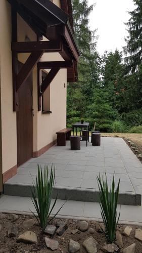 a patio with a table and two plants in front of a building at CIME Ekonomik in Brenna