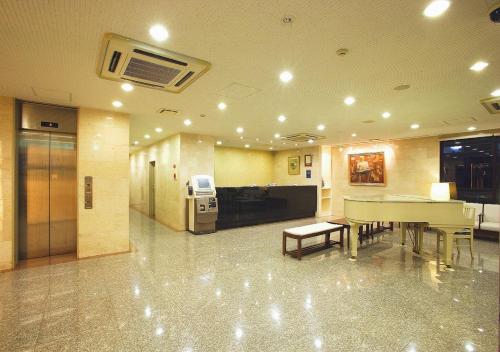 a lobby with a table and chairs in a building at Hamamatsu Hotel in Hamamatsu