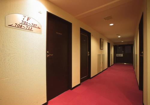 a hallway with a red carpet and a sign on the wall at Hamamatsu Hotel in Hamamatsu