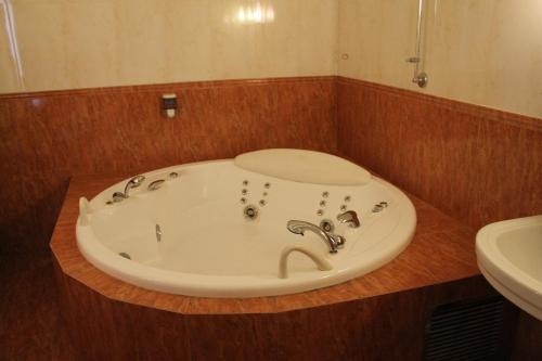 a bathroom with a bath tub with a sink at Exis Hotel in Athens