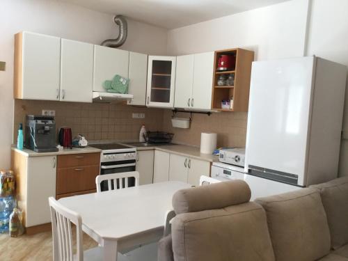 a kitchen with white cabinets and a white table and a table and chairs at JUDIA in Litomyšl