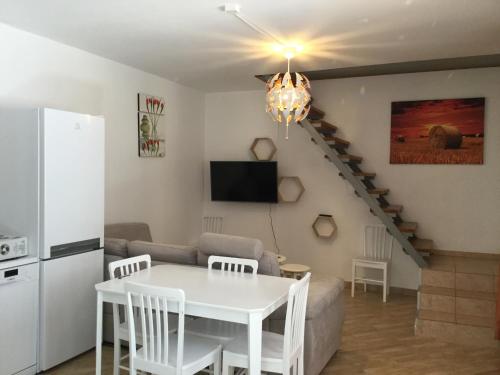 a living room with a white table and a kitchen at JUDIA in Litomyšl