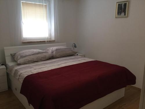 a bedroom with a bed with a red blanket and a window at JUDIA in Litomyšl