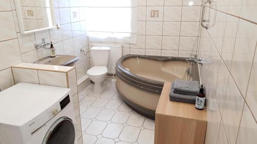 a bathroom with a tub and a toilet and a sink at Apartament Miarki 3 in Świnoujście