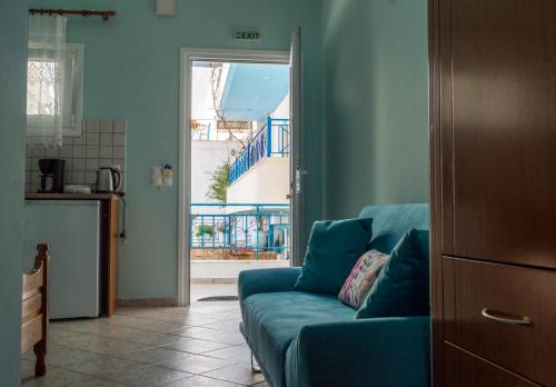 a living room with a blue couch in front of a door at Kaskanis Apartments in Vráchos