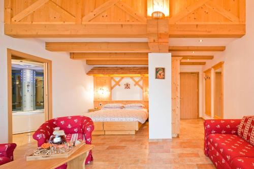 a bedroom with a bed and a red couch at Albergo San Rocco in Peio