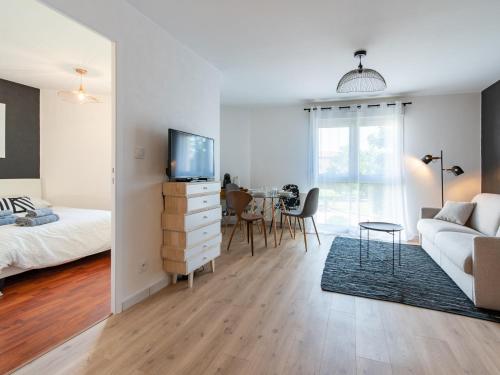 ein Wohnzimmer mit einem Bett, einem TV und einem Sofa in der Unterkunft Le Piccandet in Saint-Genis-les-Ollières