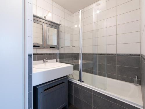 ein weißes Bad mit einem Waschbecken und einer Dusche in der Unterkunft Le Piccandet in Saint-Genis-les-Ollières