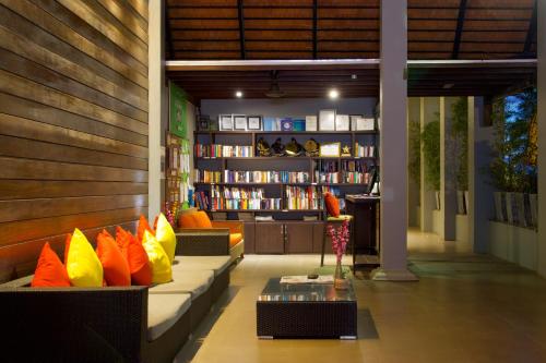 a library with a couch with colorful pillows at Chongfah Resort Khao Lak - SHA Extra Plus in Khao Lak