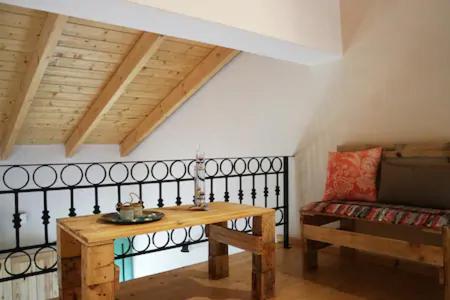 a living room with a wooden table and a couch at luxurious apartments Angelina in Karavomylos