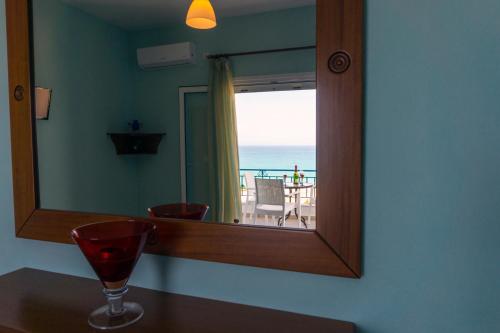 a mirror on a wall with a glass on a table at Kaskanis Apartments in Vráchos